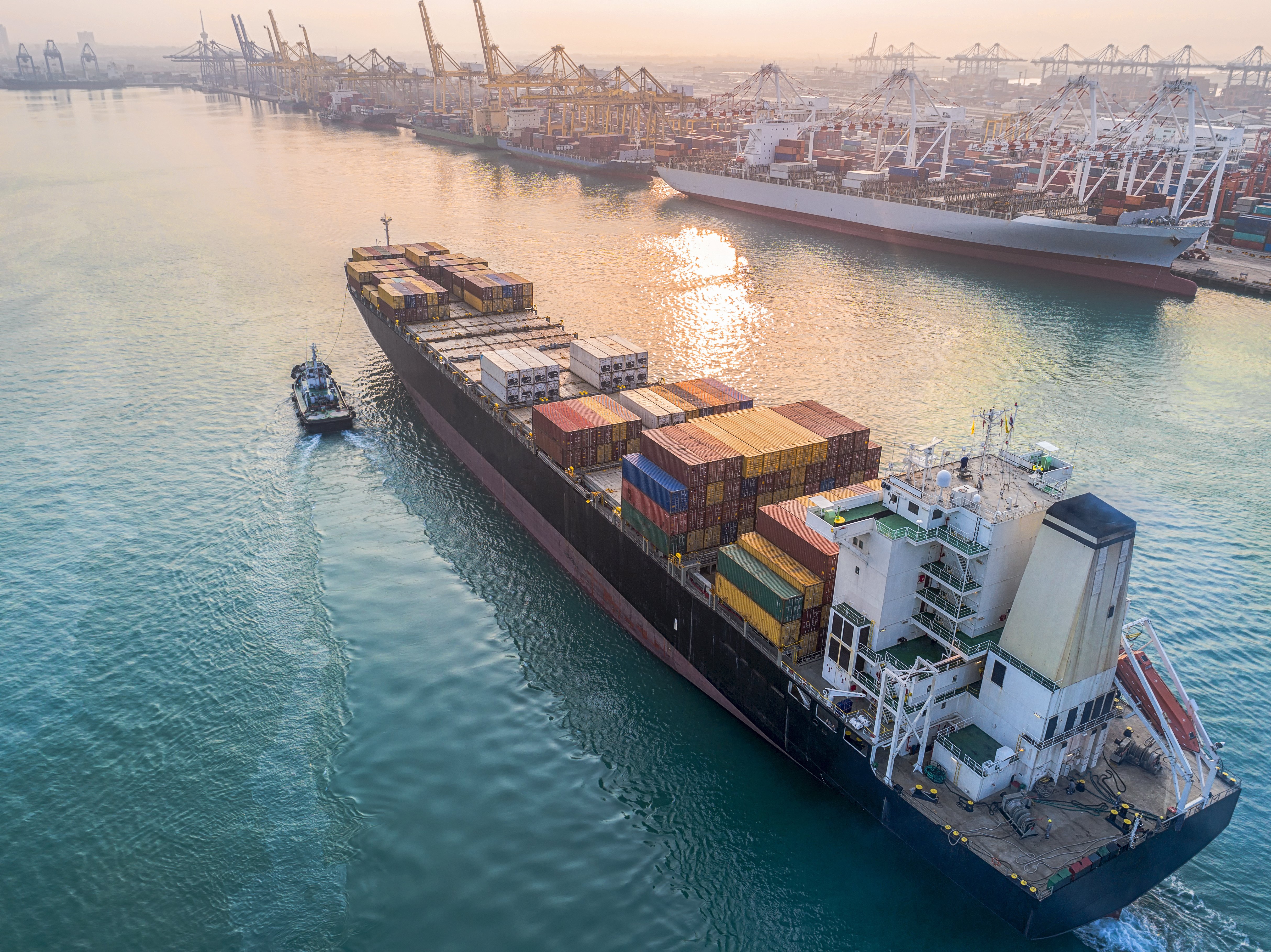 Cargo ship navigating a global port, representing international promotional product sourcing, tariffs, and supply chain strategy in 2025.